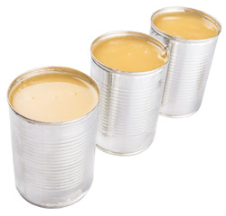 Condensed milk in tin can over white background 