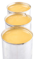 Condensed milk in tin can over white background 