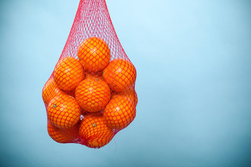 Fresh oranges fruits in mesh from supermarket