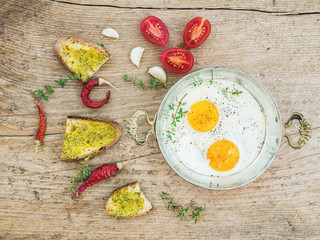 Breakfast set with roasted eggs, bread toasts with pesto souce,