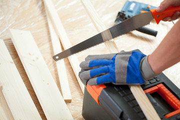 Using hand saw during house renovation