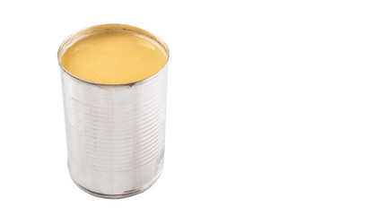 Condensed milk in tin can over white background 