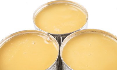 Condensed milk in tin can over white background 