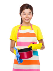 Asian housewife cleaning of saucepan