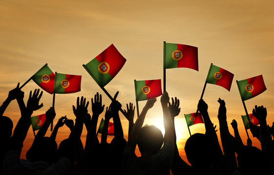 Group of People Waving Portuguese Flags Back Lit