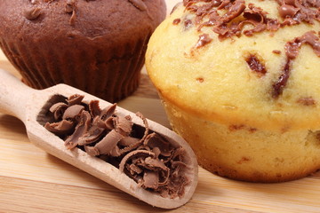 Fresh baked muffins and grated chocolate on wooden spoon