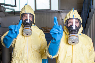 Zwei Helfer in Schutzanzuegen warnen vor Ebola