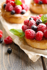 Sweet cakes with berries on table close-up