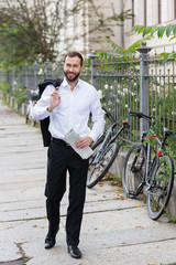 geschäftsmann mit zeitung unterwegs in der stadt