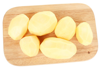 Raw peeled potatoes on wooden cutting board, isolated on white