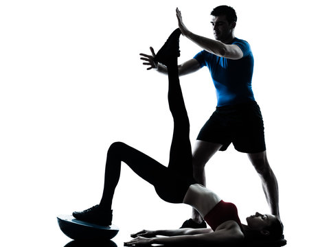 coach man woman exercising abdominals with bosu silhouette