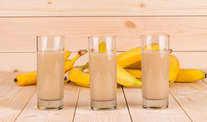 Close up of banana smoothie and fruits on wood.