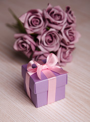 violet flowers and gift box with pink ribbon