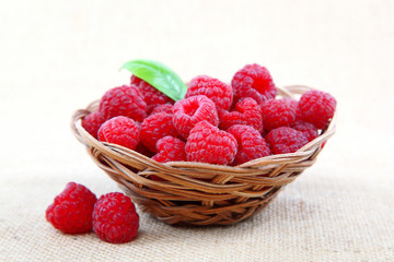 Raspberries in a basket on a homespun cloth.