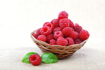 Raspberries in a basket on a homespun cloth.