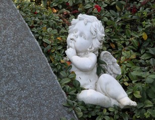 Engel liegt neben Grabstein