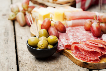 Charcuterie assortment and olives on wooden background