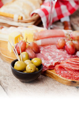 Charcuterie assortment and olives on wooden background
