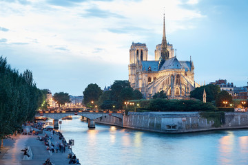 Notre Dame de Paris at dusk, people on docks - obrazy, fototapety, plakaty