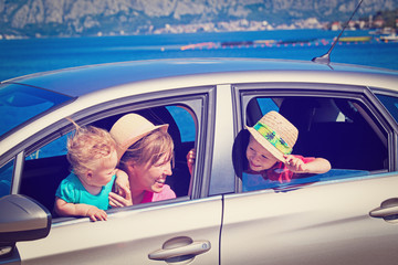 mother with kids travel by car at the sea