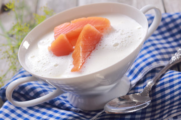Bowl of gourmet chowder with raw salmon