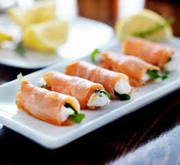 smoked salmon and arugul warp with cream cheese on platter