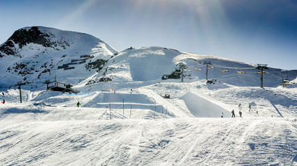 Beautiful snowy landscape with machines for skiing slope prepara