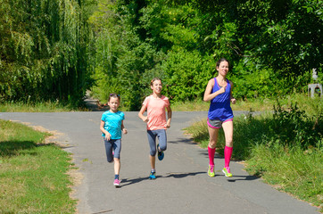 Family sport, mother and kids jogging outdoors, running in park