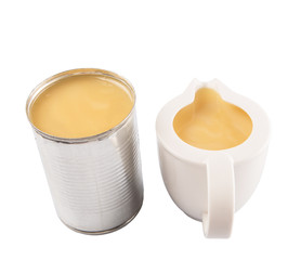 Condensed milk in tin can and milk pitcher
