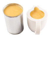 Condensed milk in tin can and milk pitcher