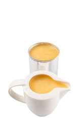 Condensed milk in tin can and milk pitcher