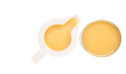 Condensed milk in tin can and milk pitcher