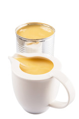 Condensed milk in tin can and milk pitcher