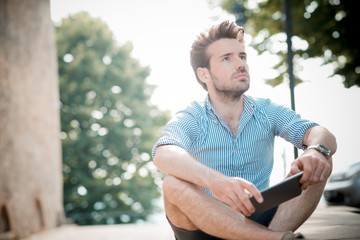 young handsome hipster modern man outdoor using tablet