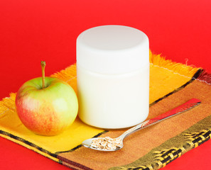 jar with yogurt isolated on red background