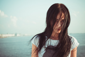 outdoor portrait young lady on beach with long mess black hair