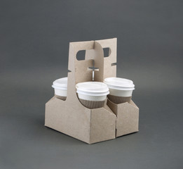take-out coffee in holder on gray background.