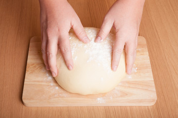 Dough on a board with your hands
