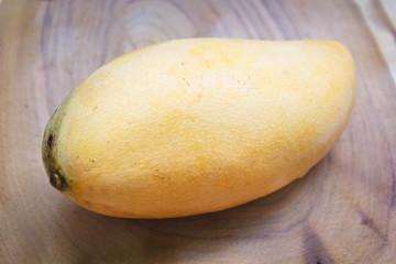 Fresh yellow ripe mango on wood  background.