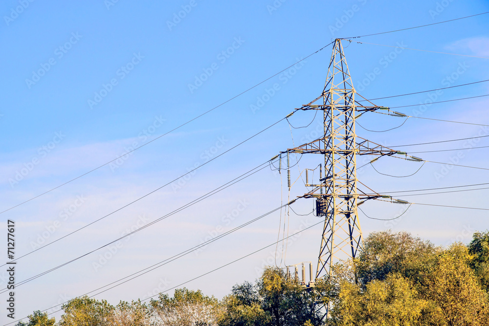 Wall mural electricity pylon against blue sky. high voltage electric cables seen from below . room for text