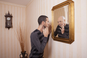 young man looking at an older himself in the mirror