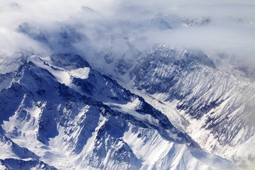 Fototapeta na wymiar Top view on snow mountains and glacier in mist