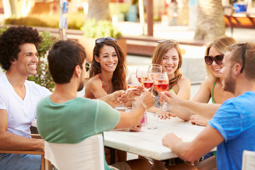 Group Of Young Friends Enjoying Meal In Outdoor Restaurant