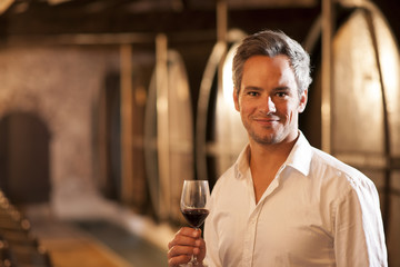 Professional winemaker tasting a glass of red wine in his tradit