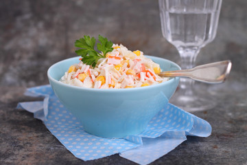 a salad of cabbage with grains of corn and crab sticks
