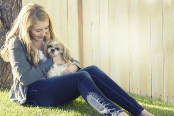 Teenage girl holding a small dog