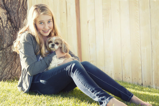 Teenage girl holding a small dog