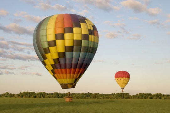 Two hot-air balloons in a field