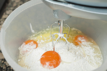 Mixing egg, flour and sugar in bowl with mixer. - 71291640
