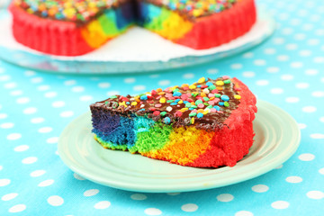 Delicious rainbow cake on plate, on tablecloth background
